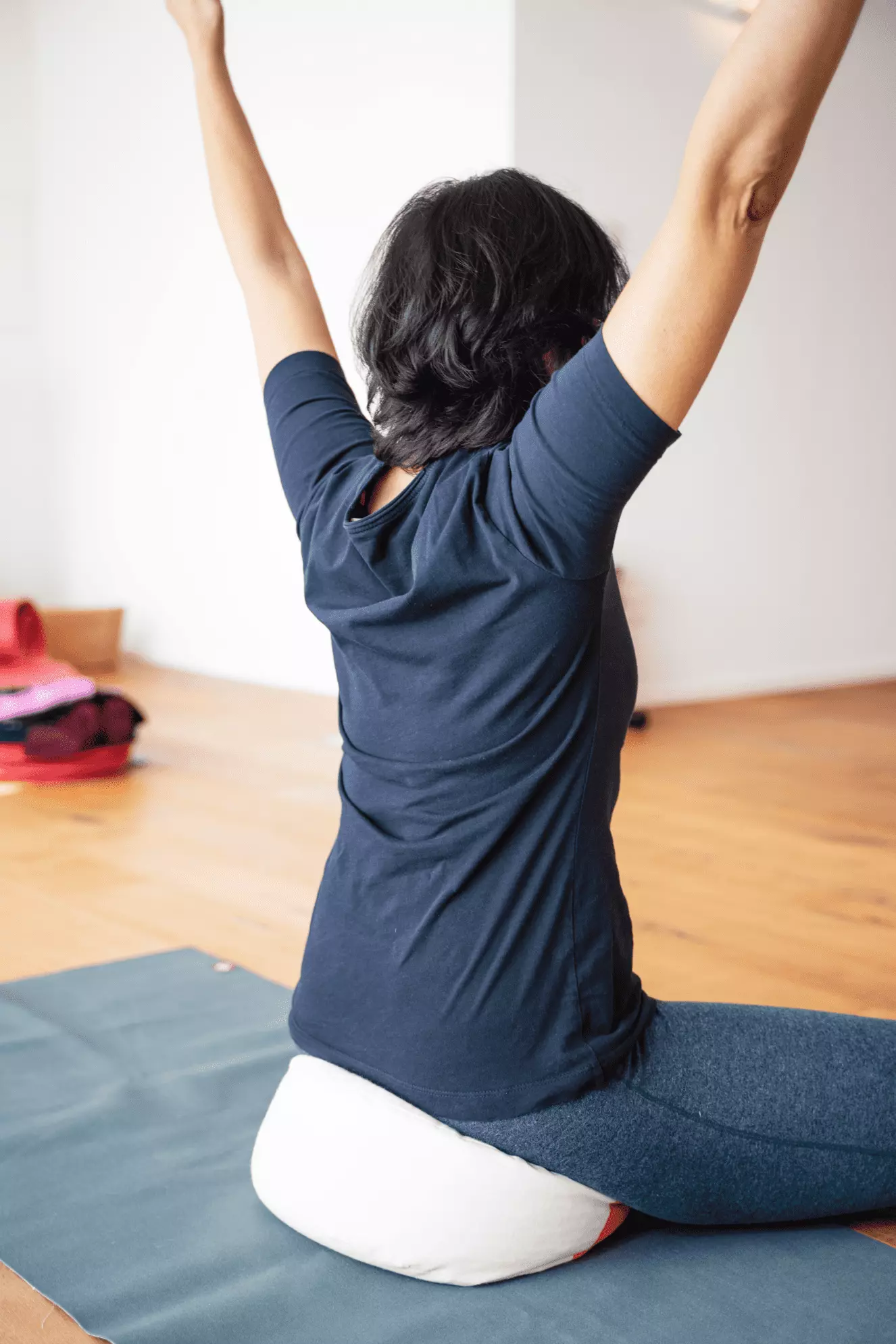 Angela Wagner in einer bequemen Sitzhaltung (sukhasana) mit erhobenen Armen